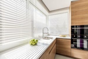 A set of white displayed inside a wooden kitchen suite displayed on a window.