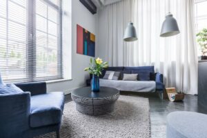 A pair of Louvolite Perfect Fit Blinds set up on a pair of windows in a living room space.