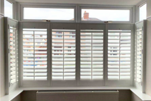 White cafe style shutters in a bay window