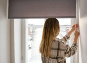 Woman opening her new blinds after visiting a blinds shop
