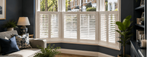 Cafe style shutters fitted to a street-facing bay window in a modern living room, providing daytime privacy while allowing natural light into the home.
