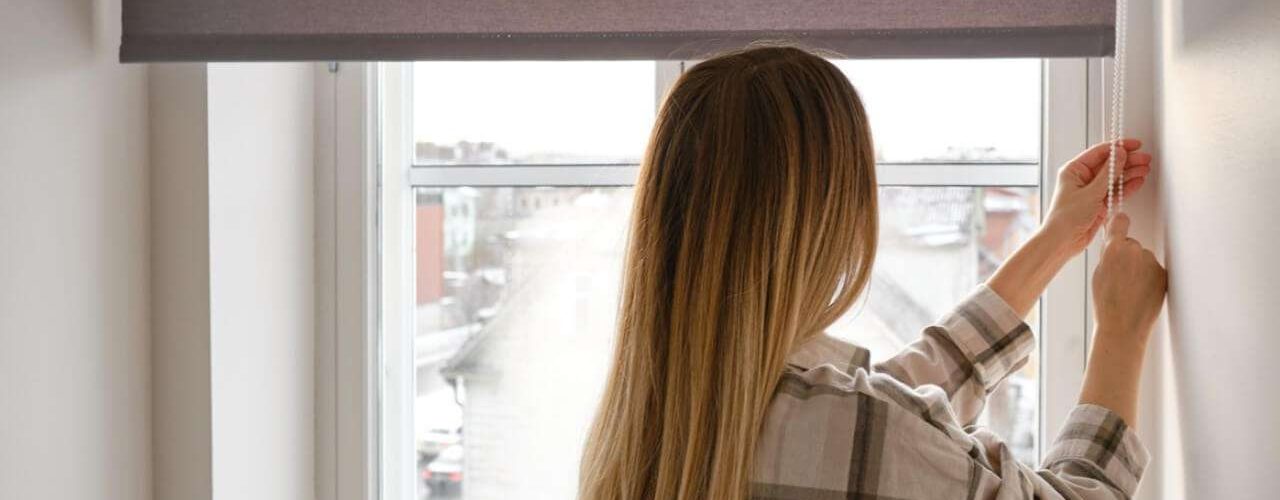 Woman opening her new blinds after visiting a blinds shop