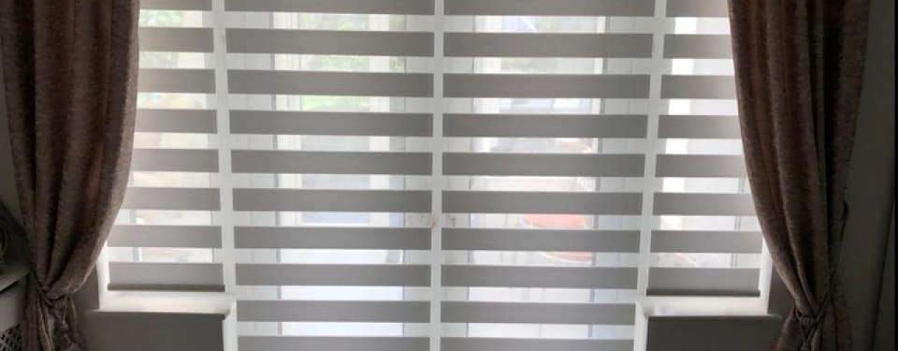 A set of day and night blinds that are fully closed to block out any light from entering the room.