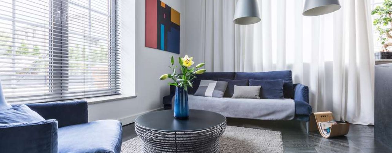 A pair of Louvolite Perfect Fit Blinds set up on a pair of windows in a living room space.