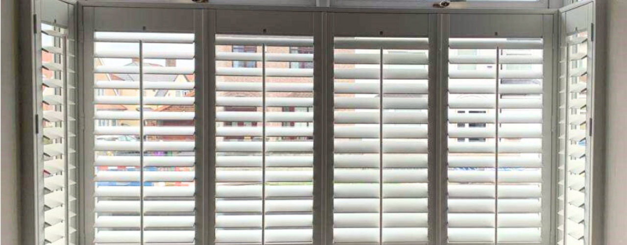 White cafe style shutters in a bay window