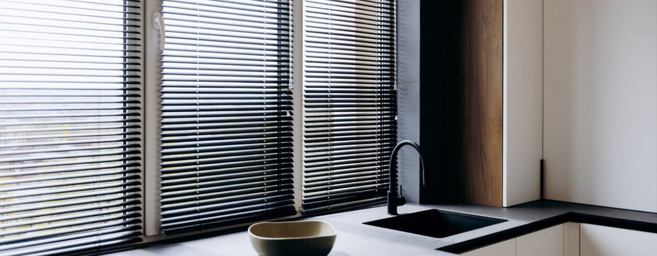 Faux wood Venetian blinds are a great solution for sunlit spaces because their composite material reflects harmful UV rays without warping